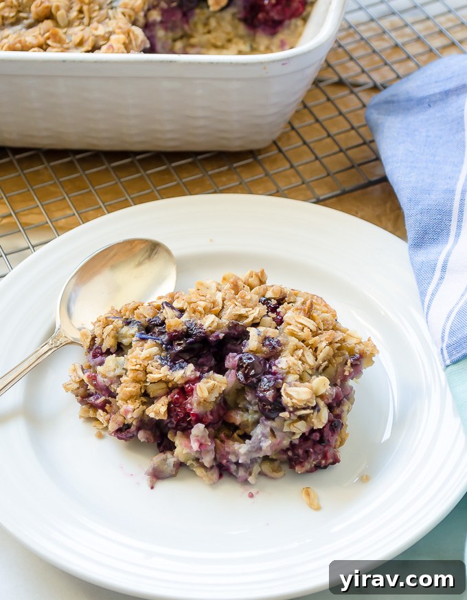 Overnight Blueberry Baked Oats Serving Serving of blueberry baked oats on a plate with a fork