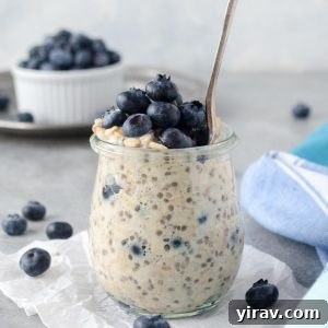 Blueberry overnight oats in a jar with spoon buried inside