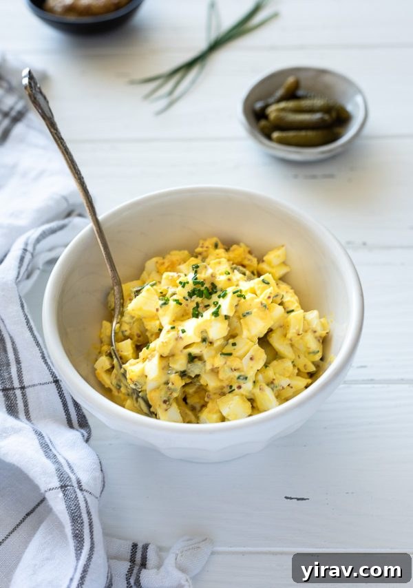 French-style egg salad in a rustic bowl, garnished with fresh chives