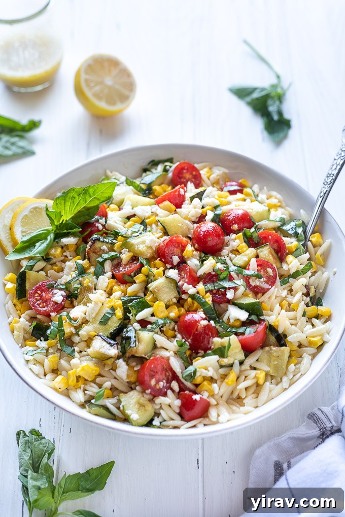 Bright Lemon Orzo Salad 7 Summer orzo pasta salad in a bowl with a spoon nestled inside