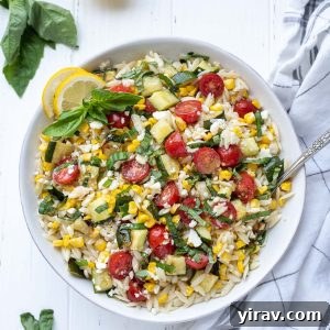 Lemon orzo pasta salad in a white bowl with basil on top