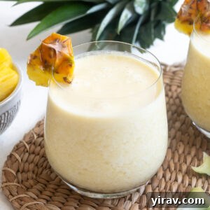 Quick & Creamy Pina Colada Dream 10 Easy pina colada in high ball glass with pineapple garnish.