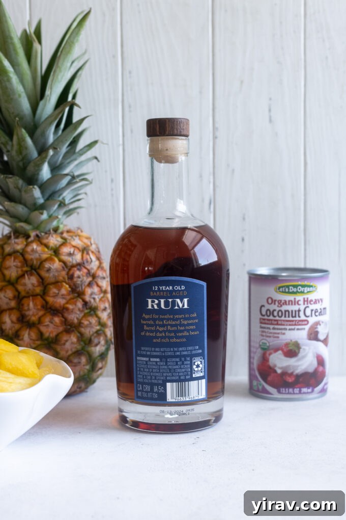 Quick & Creamy Pina Colada Dream 4 Pina colada cocktail recipe ingredients displayed on a counter, featuring pineapple, coconut cream, and rum.