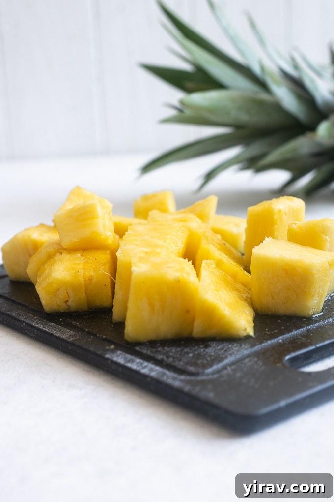 Quick & Creamy Pina Colada Dream 7 Freshly cut pineapple chunks arranged neatly on a cutting board.