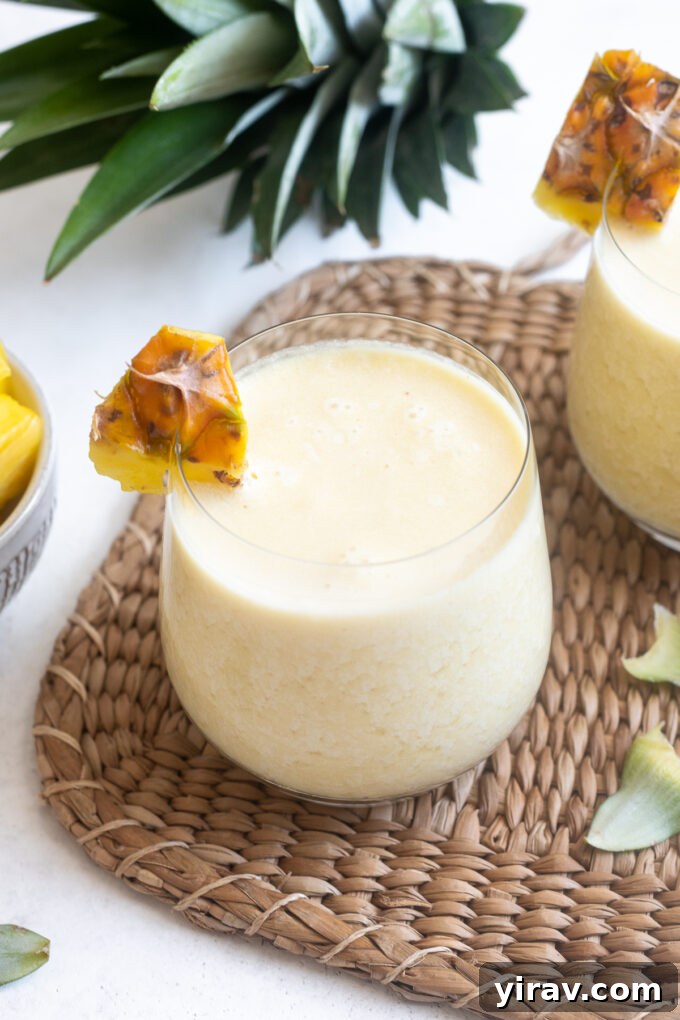 Quick & Creamy Pina Colada Dream 9 Easy pina colada in a high ball glass with pineapple garnish, refreshing and appealing.