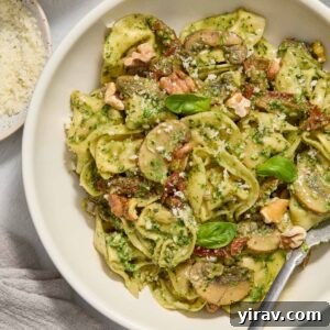 Pesto tortellini in a bowl with a fork digging in.