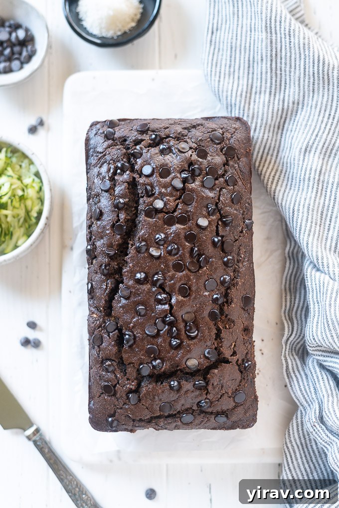 Decadent Double Chocolate Zucchini Loaf 6 A freshly baked loaf of double chocolate zucchini bread, with a knife resting alongside it, ready for slicing.