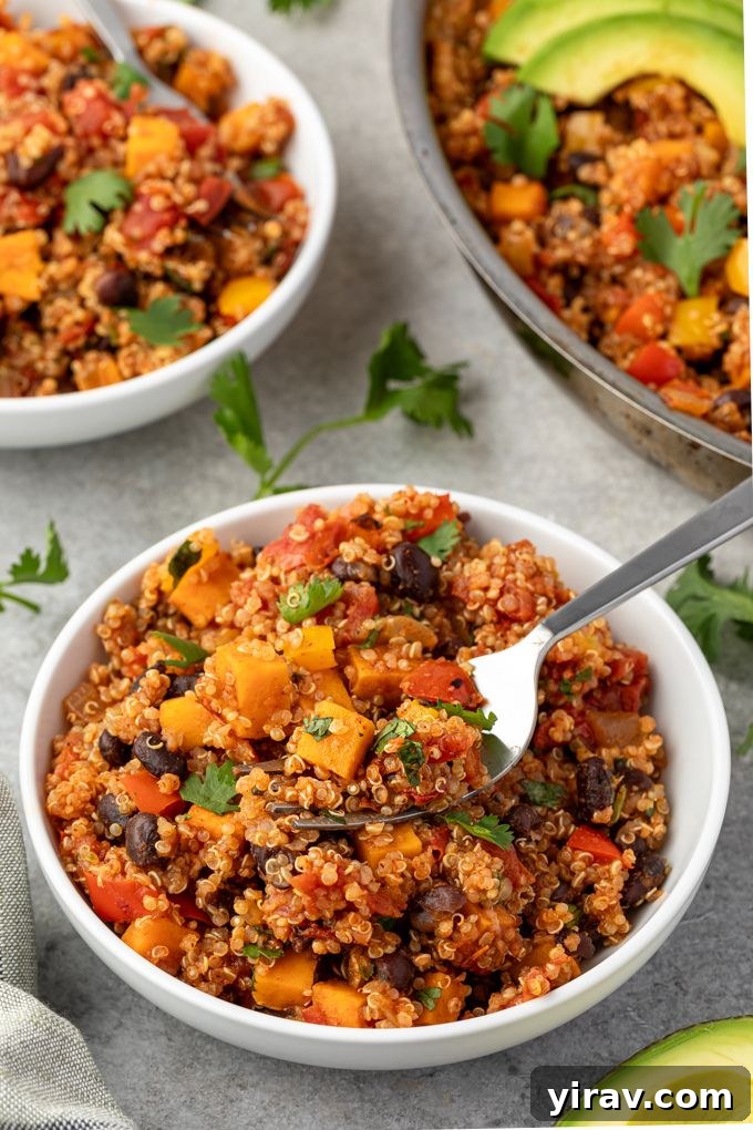 A delicious bowl of One Pot Mexican Quinoa with a fork digging in, showing the rich texture