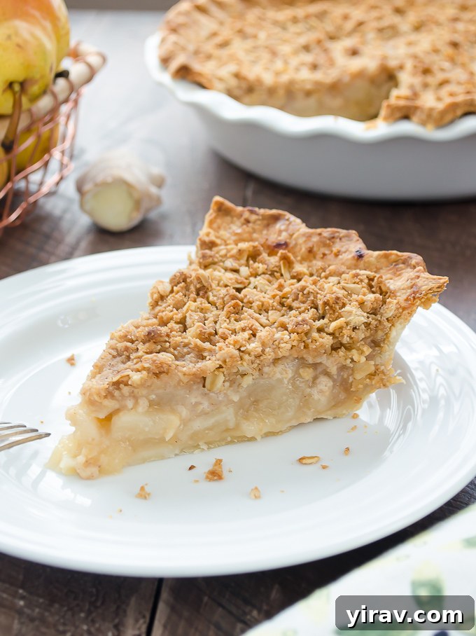 Golden Pear Pie 6 A slice of warm pear pie with streusel topping, served on a rustic plate, ready to be enjoyed.