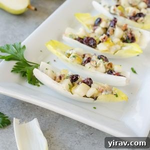 Endive salad bites on white platter with parsley garnish, ready to be served as an appetizer.