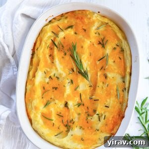 Twice baked mashed potatoes in a baking dish with rosemary on top