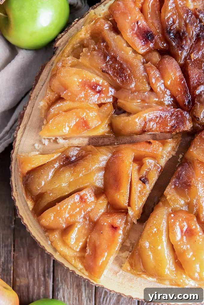 Signature Apple Tarte Tatin 3 A beautiful, golden-brown apple tarte tatin, meticulously sliced, resting on a rustic wooden serving board, ready to be enjoyed.