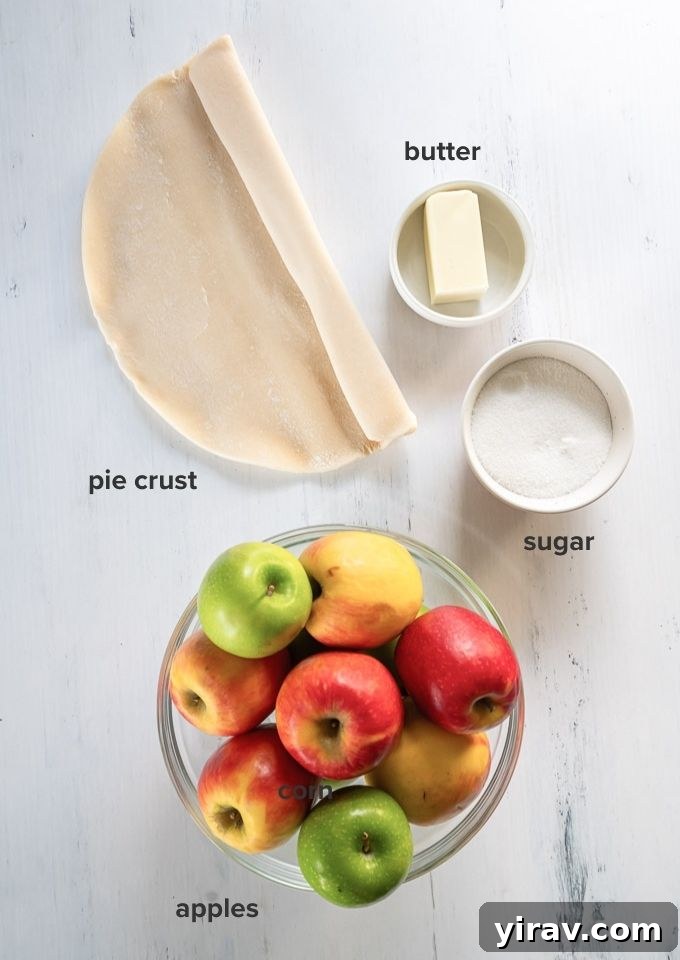 Signature Apple Tarte Tatin 4 Various raw ingredients for apple tarte tatin laid out: apples, butter, sugar, and a disc of pie dough.