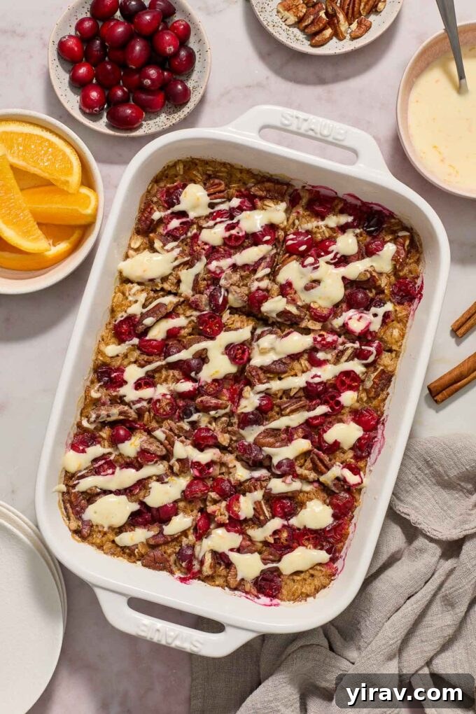Baked cranberry oatmeal with orange glaze in baking dish.