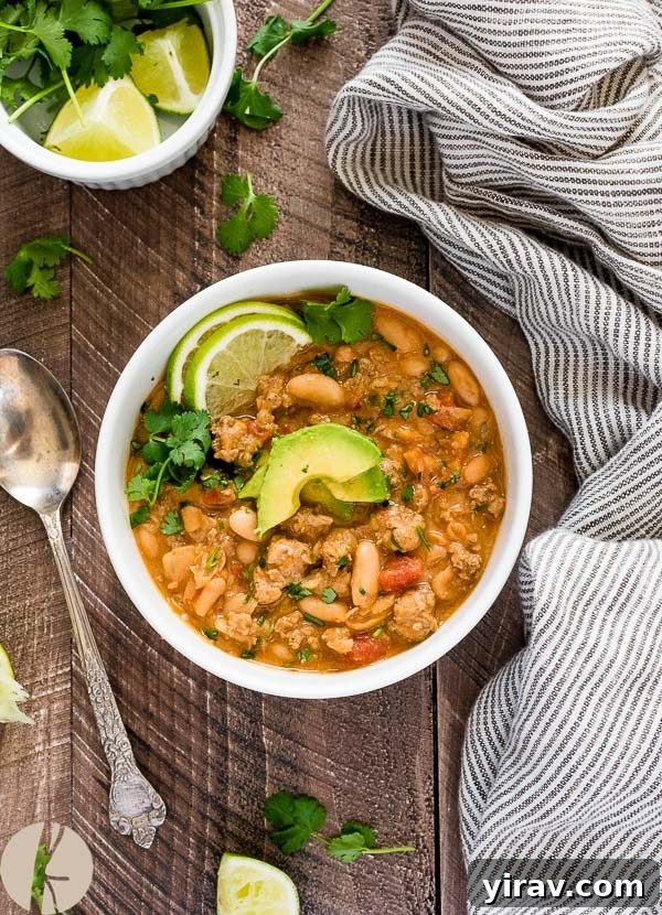 overhead shot of white bean turkey chili with avocado on top