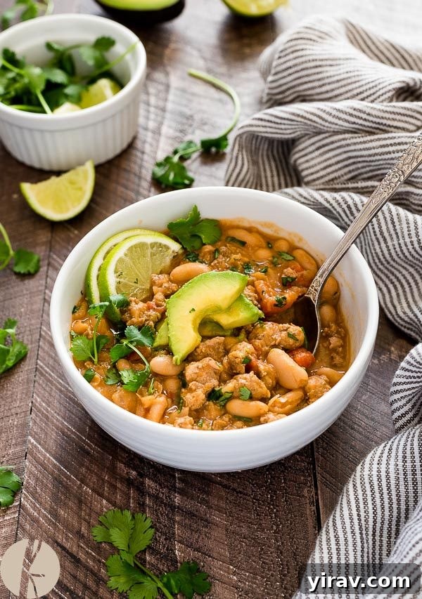 white bean turkey chili in bowl with avocado and lime on top