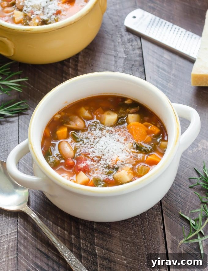 Winter minestrone soup in a white bowl with parmesan on top