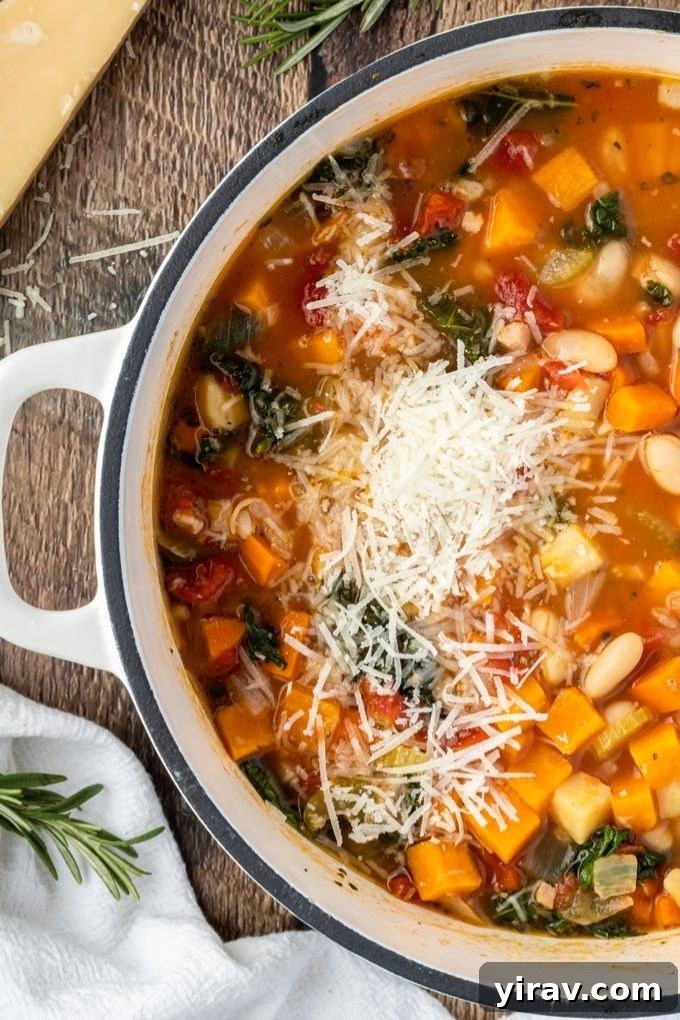 Winter minestrone soup in a white Dutch oven with parmesan on top