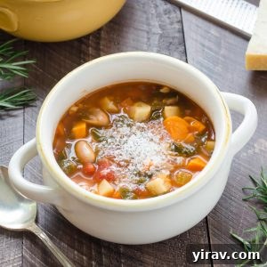 Winter minestrone soup in a white bowl with parmesan on top