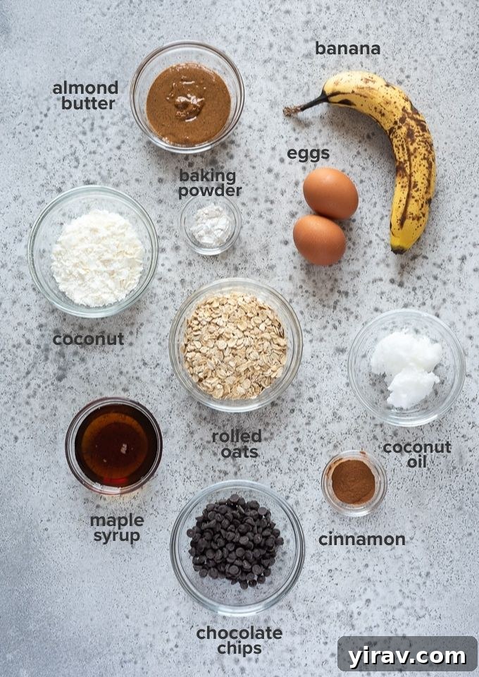 A vibrant collection of fresh, healthy ingredients laid out for making banana breakfast cookies, including ripe bananas, rolled oats, almond butter, eggs, and mini chocolate chips.