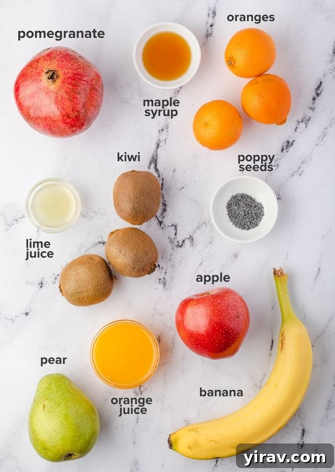 Assorted winter fruit salad recipe ingredients laid out on a white surface