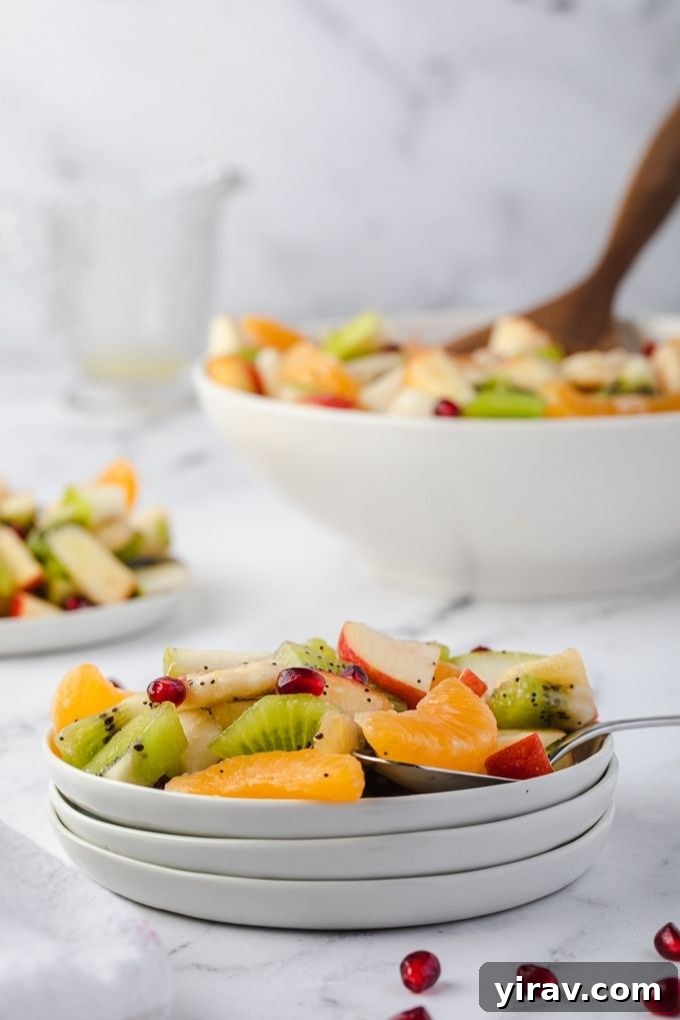 Small white plates filled with vibrant winter fruit salad, ready to be served