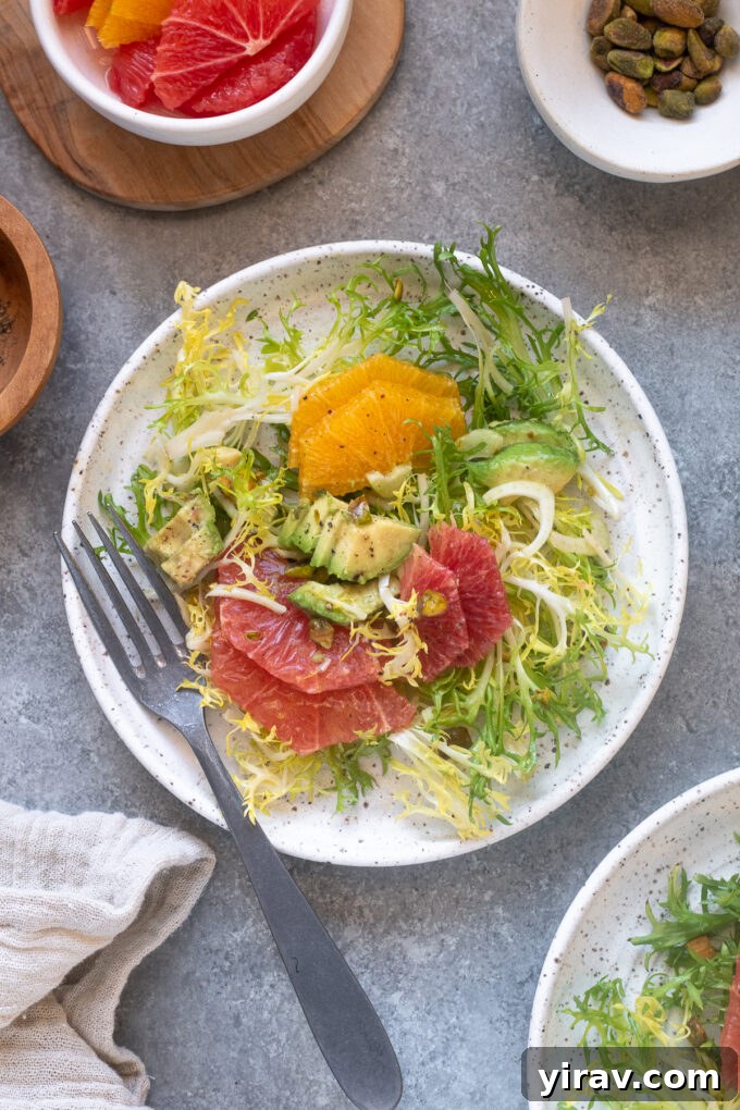Close-up of a citrus fennel salad on a white plate with a fork, showing texture and detail.