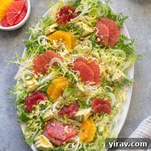 Frisée citrus salad on a platter, showcasing vibrant colors.