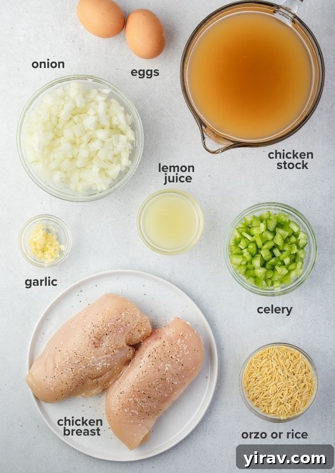 A flat lay image displaying the key ingredients for avgolemono soup: chicken breast, eggs, lemons, fresh parsley, and grains of rice.