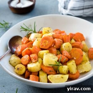 Roasted carrots and parsnips in a white bowl with spoon