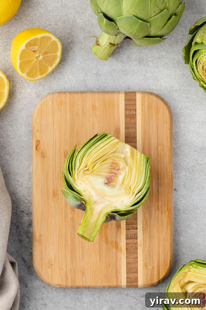 A halved artichoke clearly showing the fuzzy choke nestled in its center.
