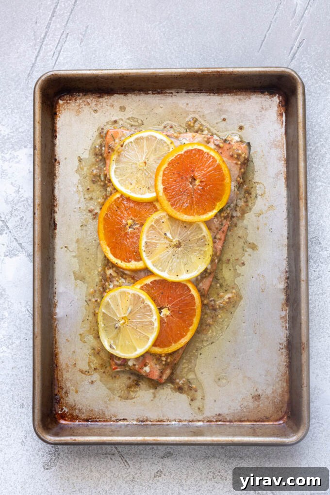 Juicy slow roasted citrus salmon on a baking sheet.