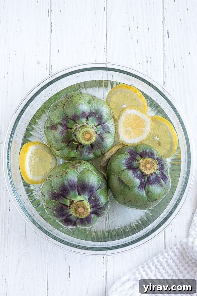 Prepped fresh artichokes in lemon water.