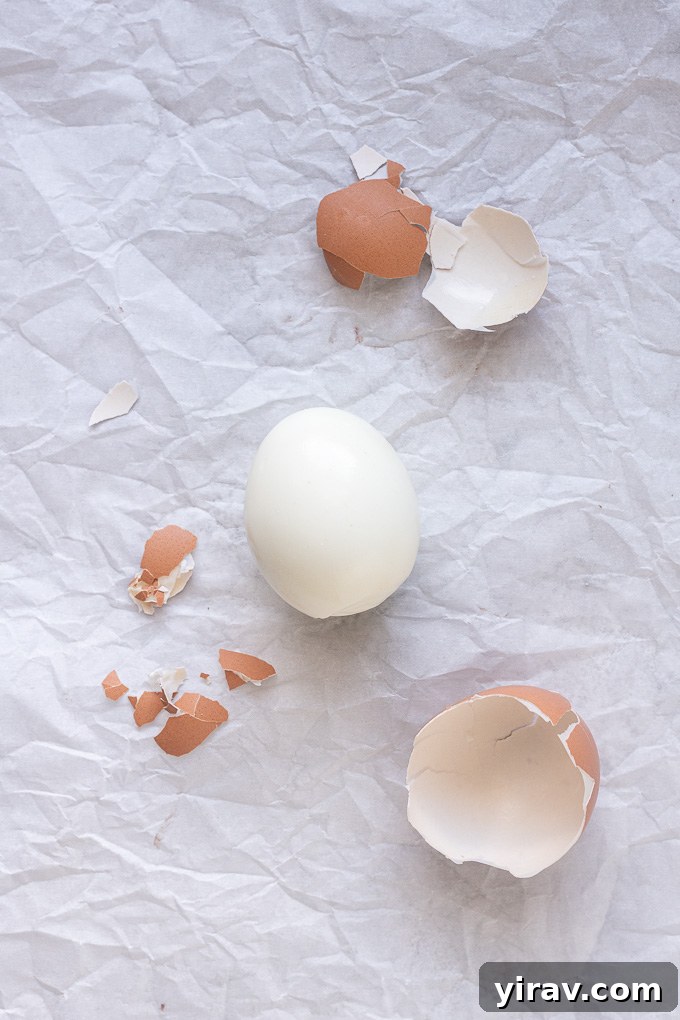 Peeled air fryer hard boiled eggs with large pieces of shell, demonstrating the ease of peeling.