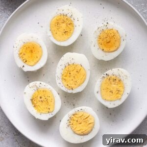 Air fryer hard boiled eggs cut in half with perfectly cooked yolks on a plate.