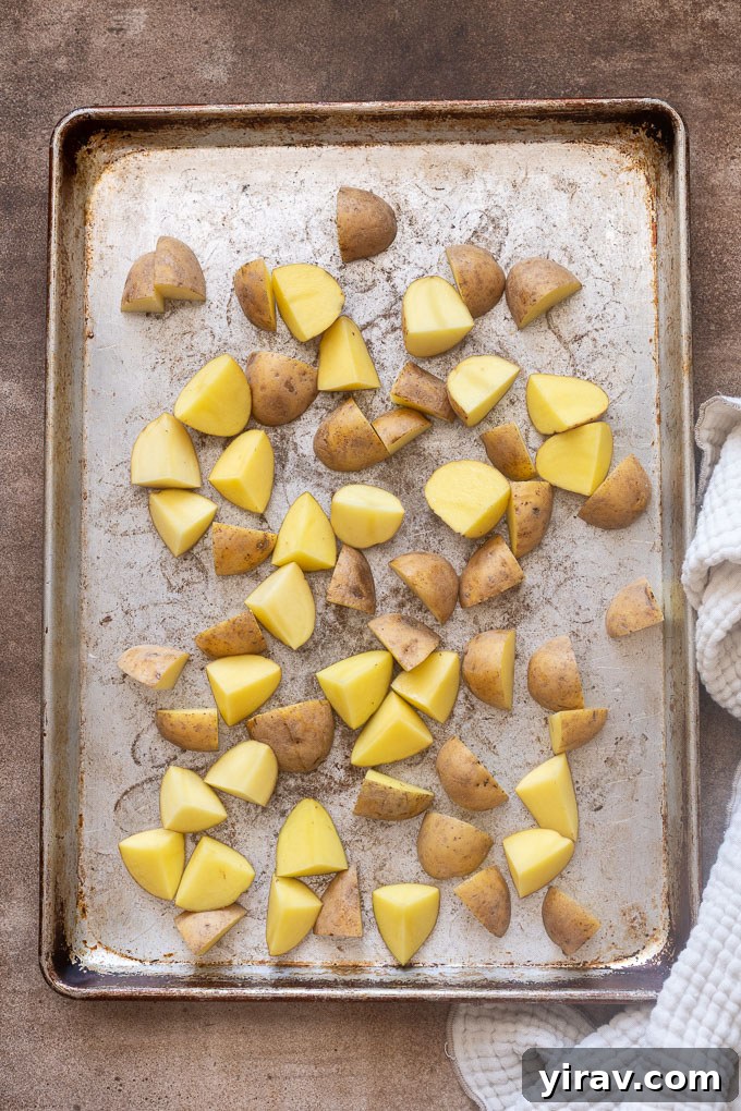 Quartered baby gold potatoes in a single layer on a baking sheet.