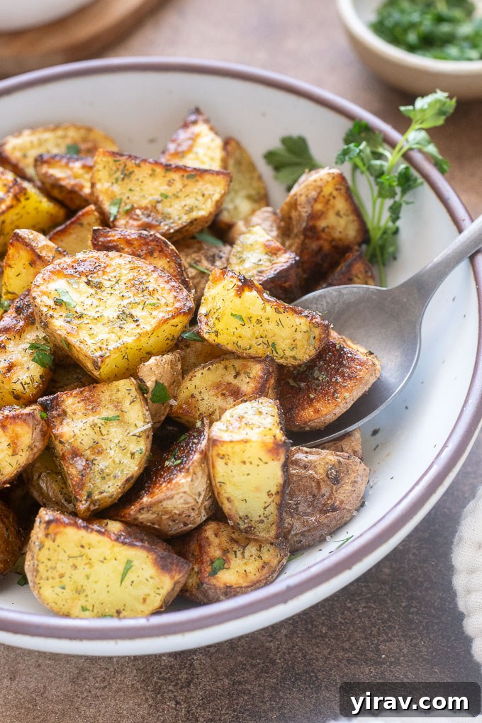 Roasted ranch potatoes in a bowl in with serving spoon.