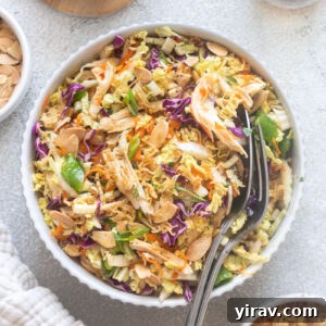 Crisp Asian Chicken Salad with Sesame Ginger Dressing 12 Chinese chicken salad with serving spoons digging into bowl.