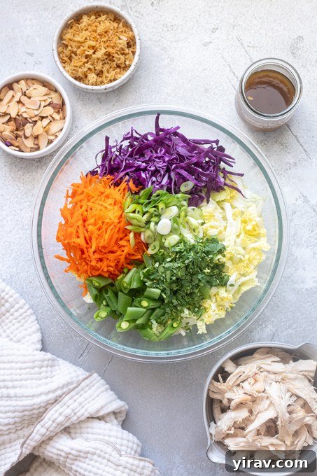 Crisp Asian Chicken Salad with Sesame Ginger Dressing 8 Chinese chicken salad ingredients sectioned in mixing bowl.