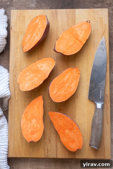 Halved sweet potatoes on a cutting board.