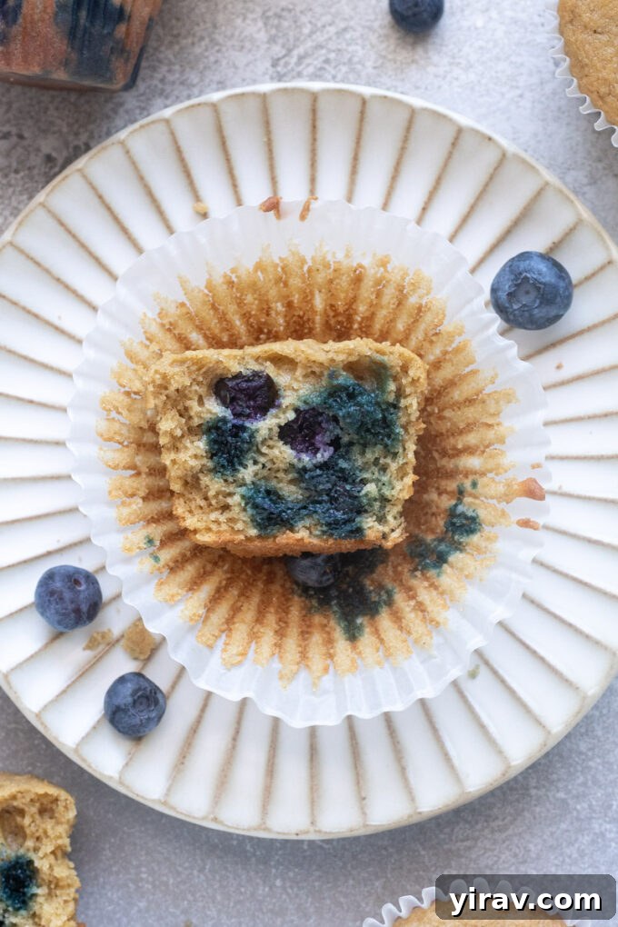 Blueberry Muffins Made with Oat Flour — Moist & Gluten-Friendly 3 Blueberry oat flour muffin on a plate cut in half to expose tender crumb.