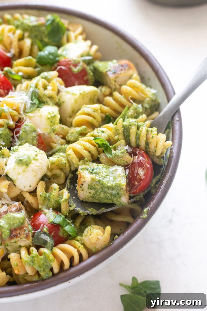 Spoonful of protein pesto pasta salad in a bowl.