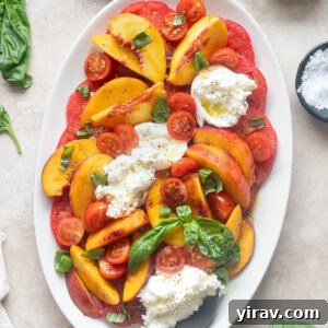 Tomato and Peach Burrata Salad Recipe 10 Tomato peach burrata salad on a platter with serving spoon.