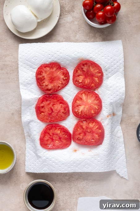 Tomato and Peach Burrata Salad Recipe 5 Sliced heirloom tomatoes on paper towels.