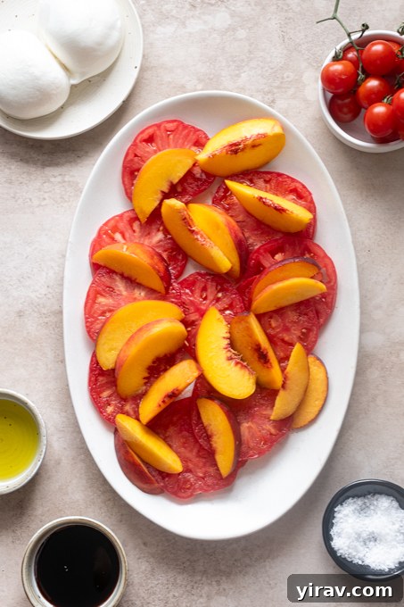 Tomato and Peach Burrata Salad Recipe 6 Heirloom tomatoes and peaches layered on a platter.