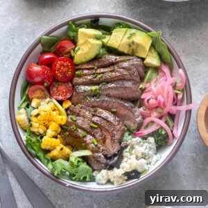 Grilled steak salad in bowl with chopped chives on top.