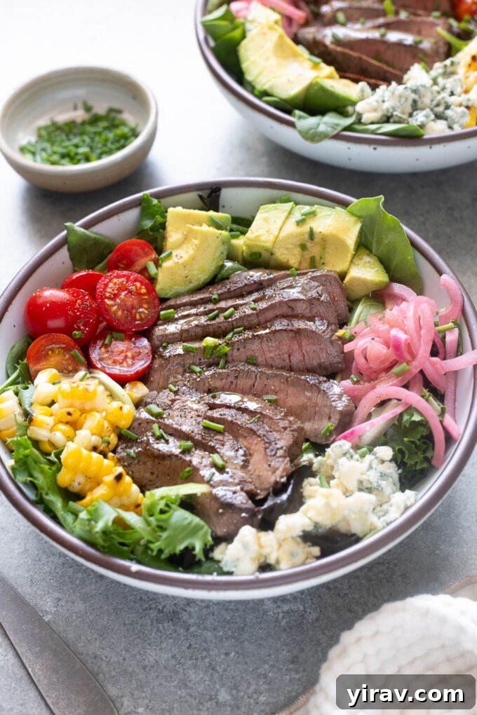 Grilled steak salad with sliced top sirloin, avocado, corn, tomatoes and blue cheese.