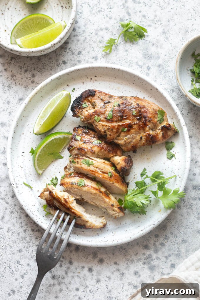 Cilantro-Lime Grilled Chicken with Zesty Marinade 10 Grilled cilantro lime chicken sliced on a dinner plate with lime wedges.