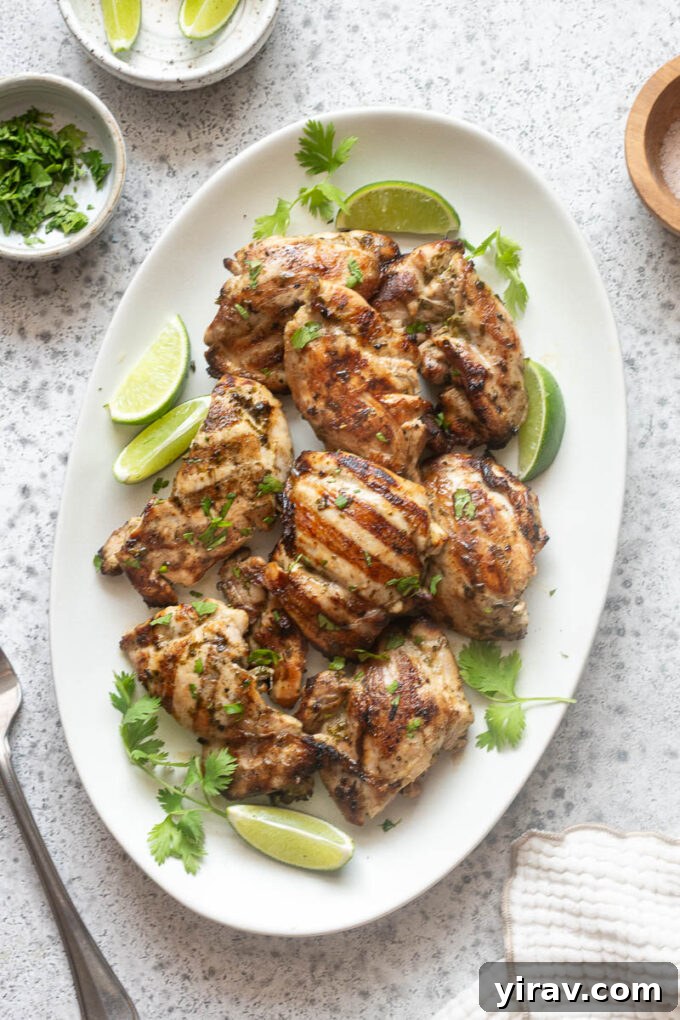 Cilantro-Lime Grilled Chicken with Zesty Marinade 3 Overhead view of grilled cilantro lime chicken arranged on a white serving platter.