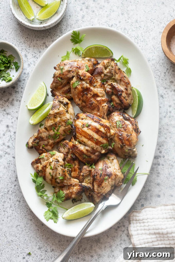 Cilantro-Lime Grilled Chicken with Zesty Marinade 9 Grilled cilantro lime chicken on a platter with lime wedges and cilantro.